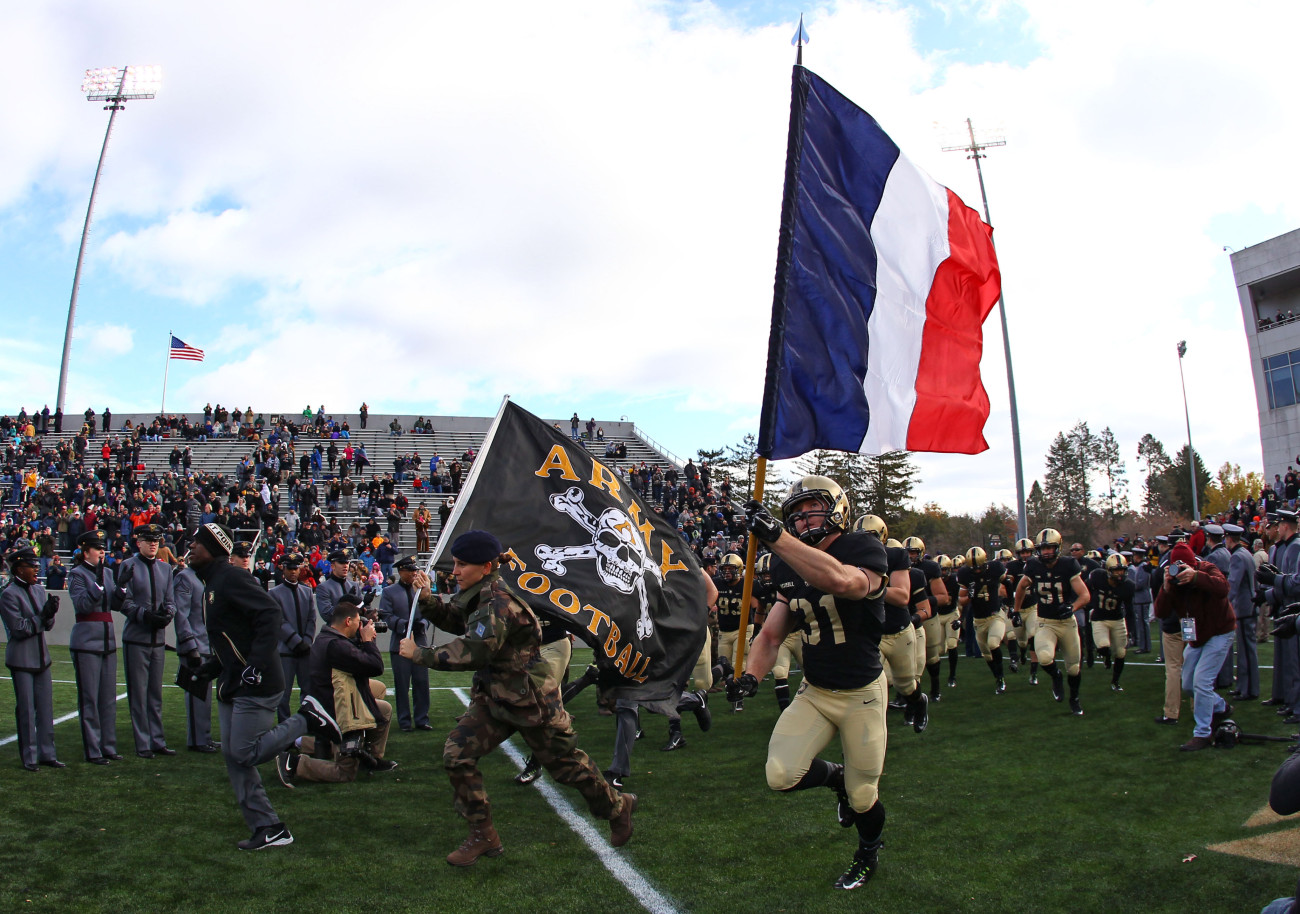 Nov 14, 2015; West Point, NY, USA; Army Black Knights defensive back Caleb McNeill (31) carries a French flag on to the field alongside a French exchange cadet before a game against the Tulane Green Wave at Michie Stadium. Army honored the French a day after terrorist attacks in Paris, France. Mandatory Credit: Danny Wild-USA TODAY Sports